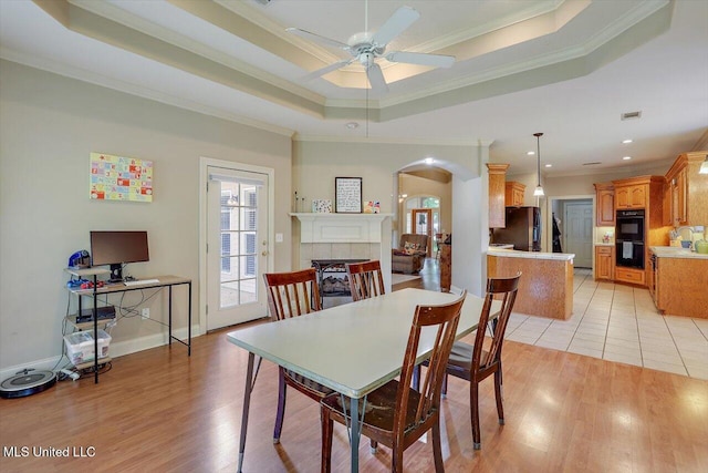 109 Bellemeade Trce, Clinton, MS 39056 - dining room featuring arched walkways, ornamental molding, a ceiling fan, a fireplace, and light wood finished floors