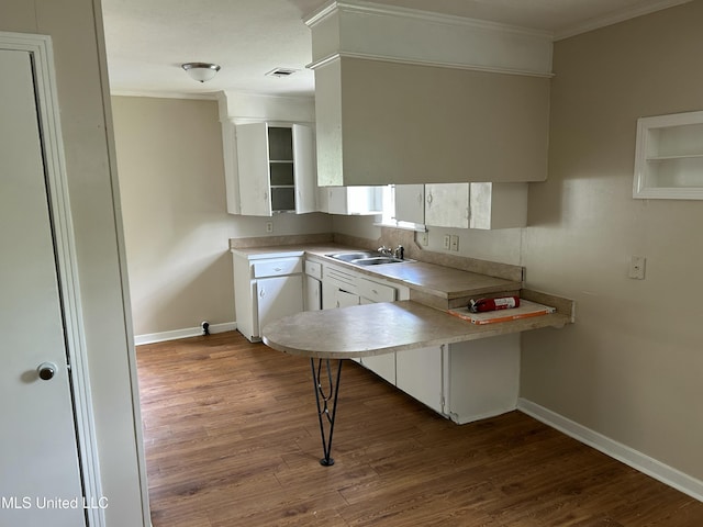 1110 Barbara Ann Dr, Jackson, MS 39204 - kitchen with dark wood-style floors, crown molding, a peninsula, and visible vents