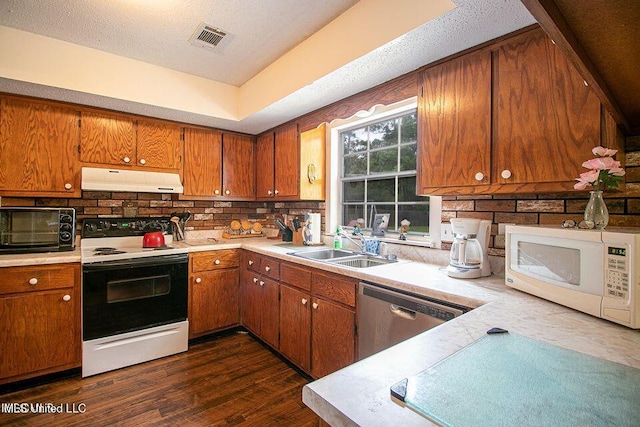 kitchen with visible vents, white microwave, under cabinet range hood, dishwasher, and range with electric stovetop