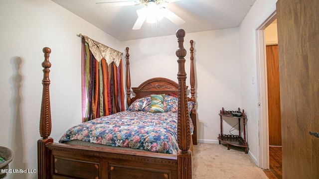 bedroom featuring baseboards, a textured ceiling, ceiling fan, and light colored carpet