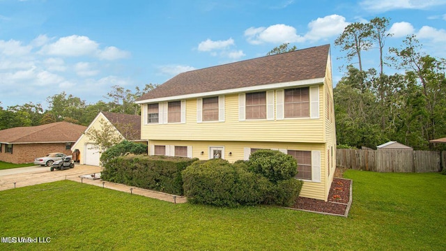 colonial inspired home featuring driveway, fence, a garage, a shingled roof, and a front yard