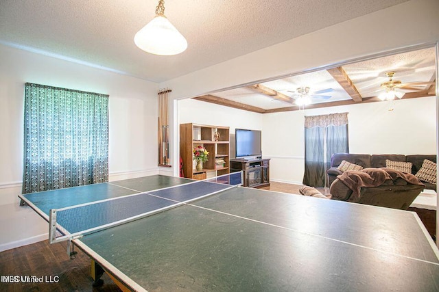 playroom with baseboards, dark wood-style flooring, beam ceiling, and a textured ceiling