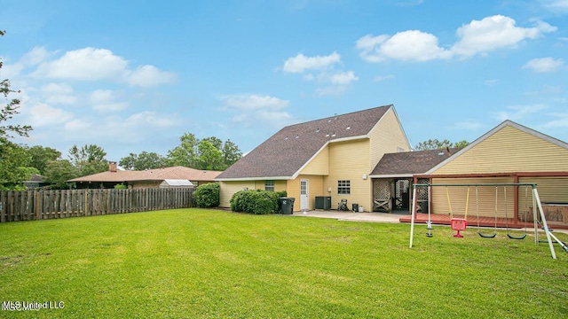 back of house featuring a patio, central AC unit, a fenced backyard, a yard, and roof with shingles