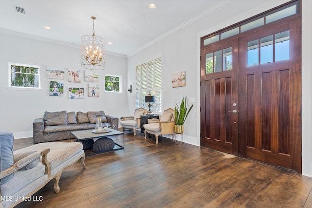 foyer with dark hardwood / wood-style flooring, a chandelier, and ornamental molding