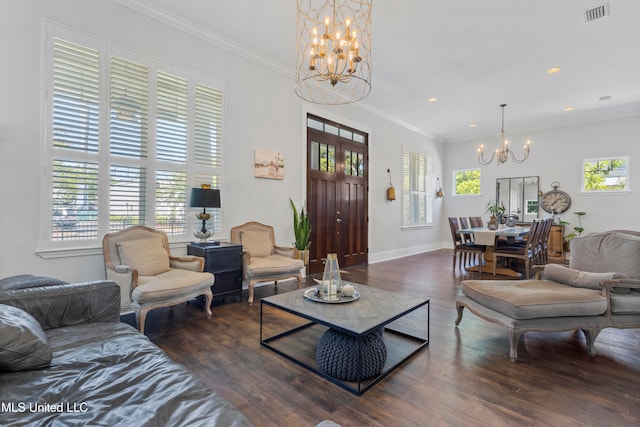 living room with dark hardwood / wood-style floors, crown molding, and an inviting chandelier