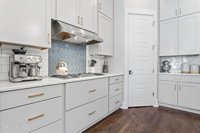 kitchen with white cabinets, dark hardwood / wood-style floors, stainless steel gas cooktop, and tasteful backsplash