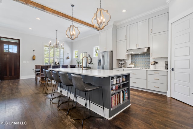 kitchen with white cabinetry, an island with sink, dark hardwood / wood-style floors, and appliances with stainless steel finishes