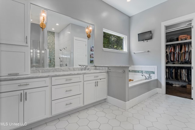 bathroom featuring shower with separate bathtub, vanity, and tile patterned floors