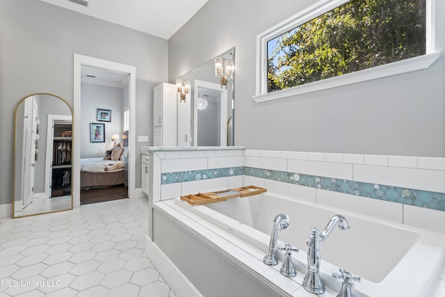 bathroom featuring tiled bath and tile patterned flooring