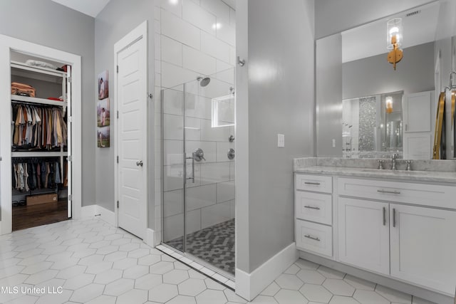 bathroom with tile patterned flooring, vanity, and walk in shower