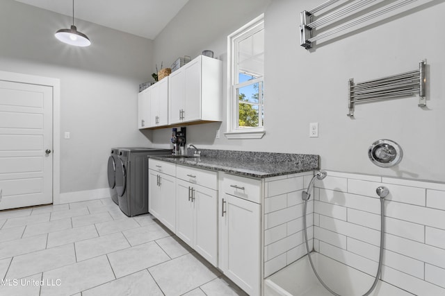 laundry room featuring radiator, sink, light tile patterned floors, and washer and dryer