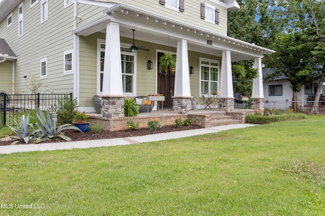 view of front facade with a front yard, ceiling fan, and covered porch