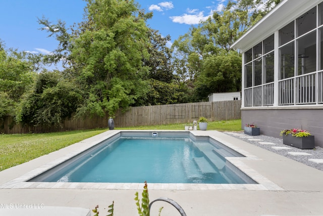 view of swimming pool featuring a lawn and a sunroom