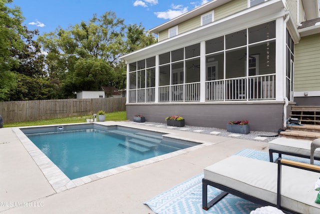 view of swimming pool with a sunroom and a patio