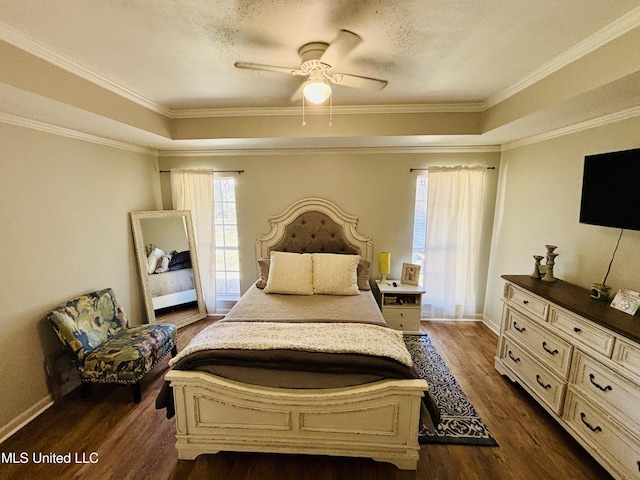 bedroom with dark wood-type flooring, a textured ceiling, ceiling fan, and a raised ceiling