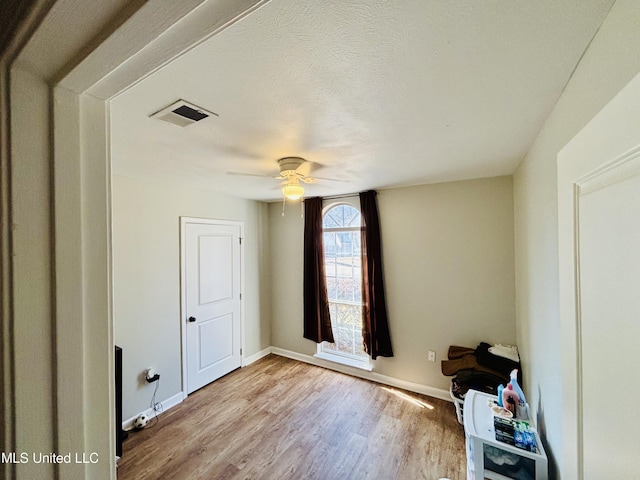 interior space with light hardwood / wood-style floors, a textured ceiling, and ceiling fan