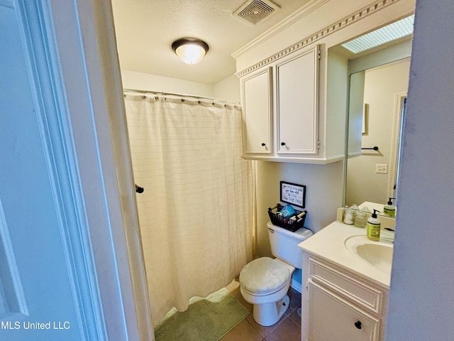 bathroom with vanity, toilet, tile patterned floors, and a textured ceiling