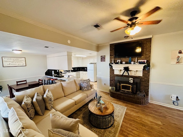 living room with hardwood / wood-style flooring, ceiling fan, crown molding, and a textured ceiling