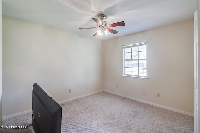 carpeted spare room with ceiling fan