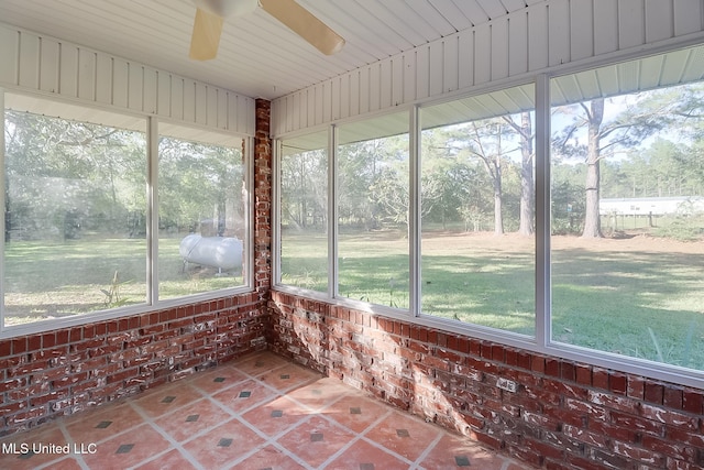 unfurnished sunroom featuring ceiling fan