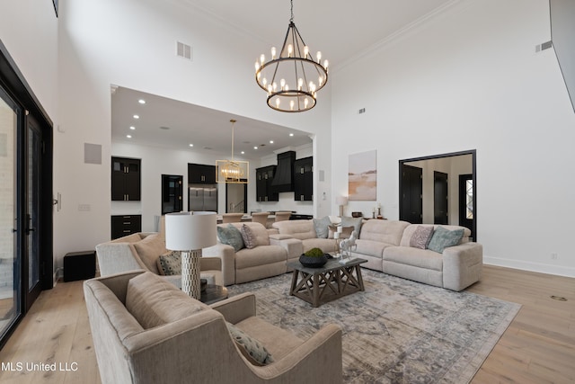 living area with ornamental molding, light wood-type flooring, and a high ceiling