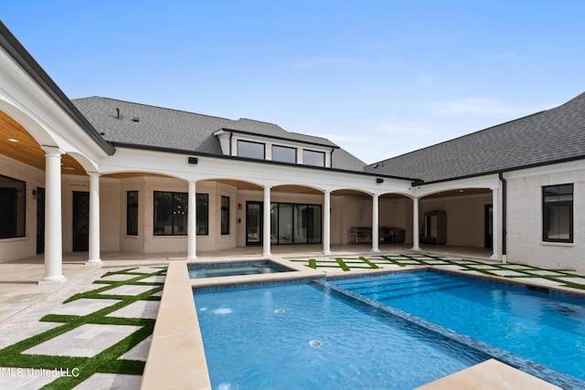 view of pool with a patio and a pool with connected hot tub