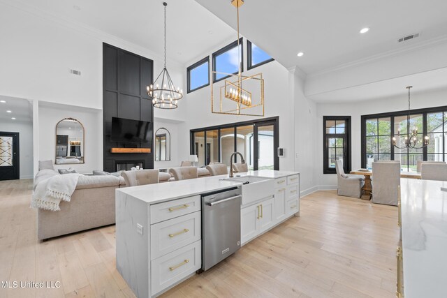 kitchen featuring visible vents, light wood-style flooring, stainless steel dishwasher, a chandelier, and a sink