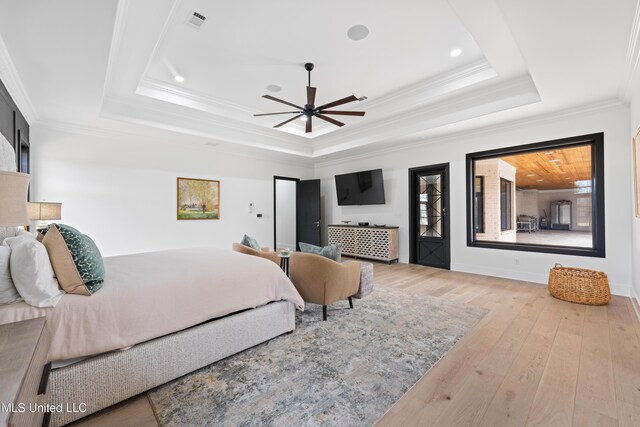 bedroom featuring visible vents, baseboards, ornamental molding, hardwood / wood-style floors, and a raised ceiling