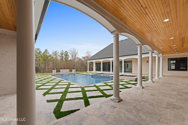 view of pool with a patio area, fence, a fenced in pool, and an in ground hot tub