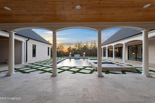 view of patio with an in ground hot tub, fence, and an outdoor pool