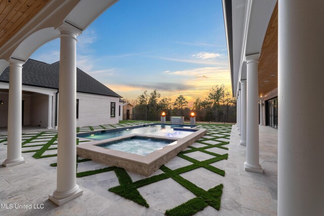 outdoor pool with a patio and an in ground hot tub