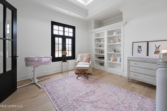 living area with french doors, crown molding, baseboards, and wood finished floors