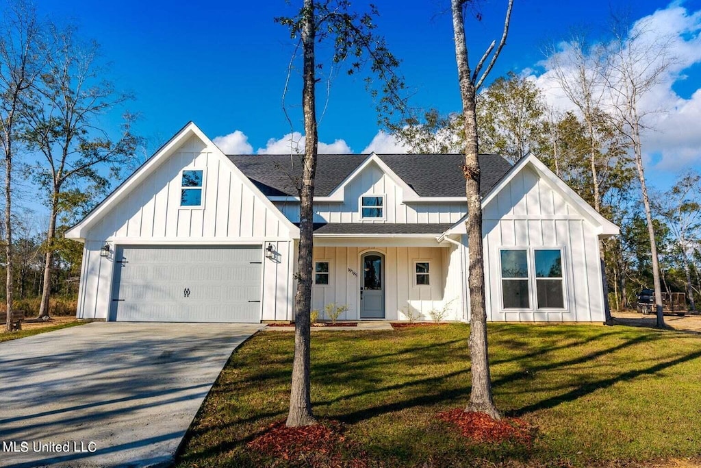 modern farmhouse style home with a front yard and a garage