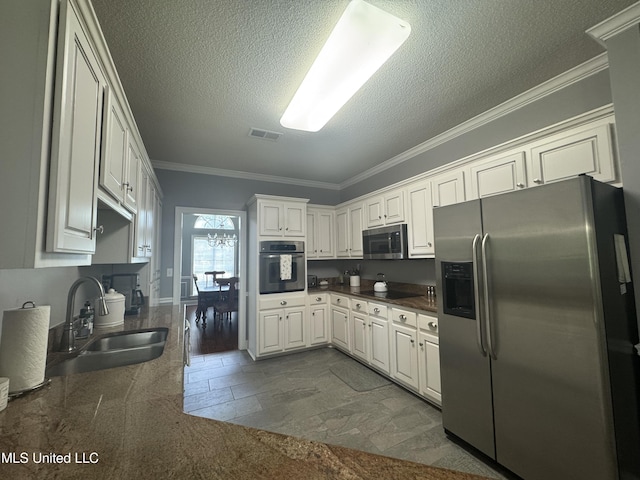 2610 Dickens Place Dr, Southaven, MS 38671 - kitchen with stainless steel appliances, crown molding, dark countertops, a textured ceiling, and white cabinetry