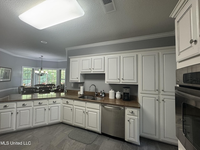 2610 Dickens Place Dr, Southaven, MS 38671 - kitchen with stainless steel appliances, white cabinets, a chandelier, crown molding, and dark countertops