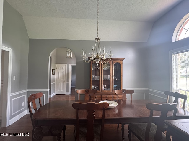 2610 Dickens Place Dr, Southaven, MS 38671 - dining area featuring lofted ceiling, a chandelier, arched walkways, a wainscoted wall, and a textured ceiling