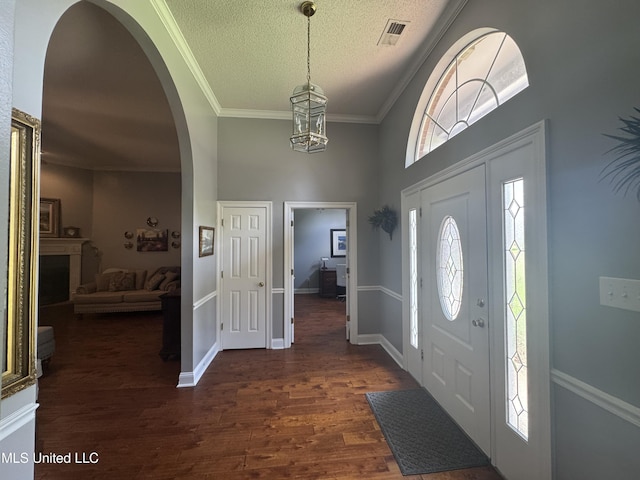 2610 Dickens Place Dr, Southaven, MS 38671 - foyer entrance featuring a towering ceiling, arched walkways, a textured ceiling, dark wood-type flooring, and a chandelier