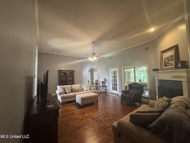 2610 Dickens Place Dr, Southaven, MS 38671 - living room featuring arched walkways, ornamental molding, a textured ceiling, a fireplace, and dark wood-style flooring