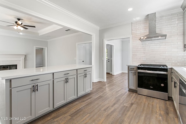 kitchen featuring wall chimney exhaust hood, stainless steel range, dark hardwood / wood-style floors, and gray cabinets