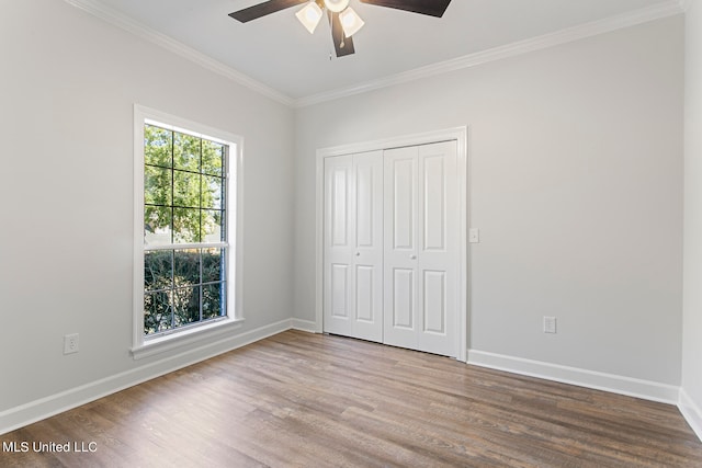 unfurnished bedroom with a closet, ceiling fan, hardwood / wood-style flooring, and ornamental molding