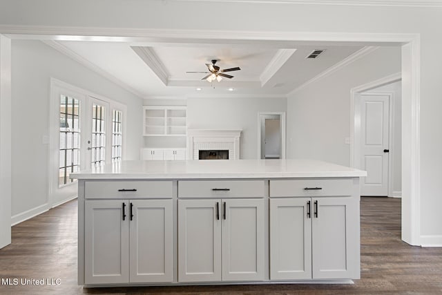 kitchen with ornamental molding, a kitchen island, and dark hardwood / wood-style flooring