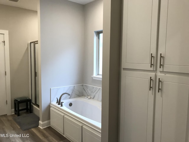 bathroom with hardwood / wood-style floors and separate shower and tub