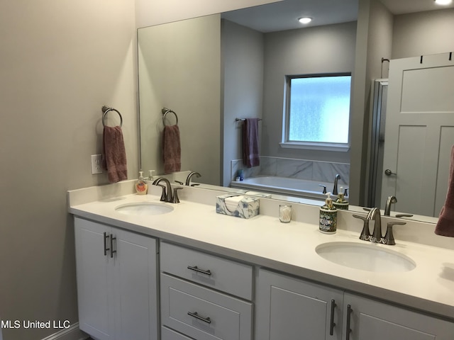 bathroom with a washtub and vanity