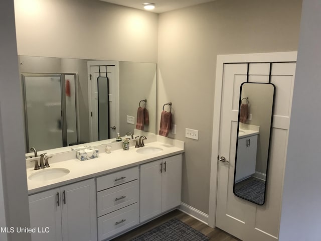 bathroom with hardwood / wood-style floors, vanity, and a shower with shower door