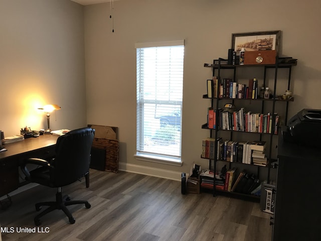 office with dark hardwood / wood-style floors and plenty of natural light