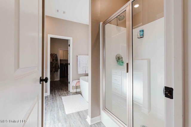 bathroom featuring wood-type flooring and independent shower and bath