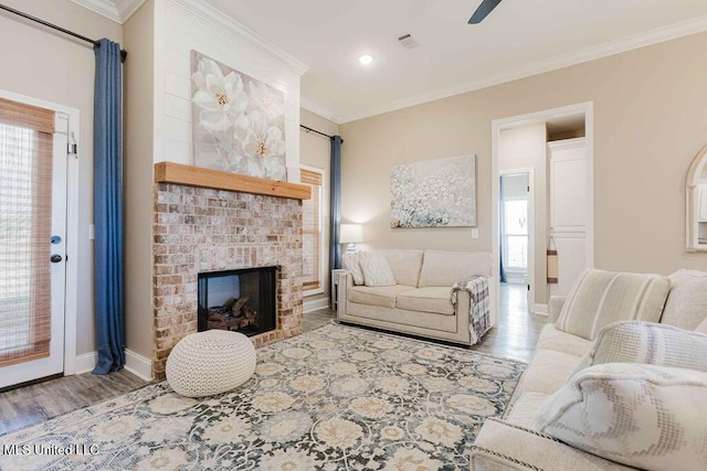 living room featuring a fireplace, light hardwood / wood-style floors, a wealth of natural light, and ornamental molding