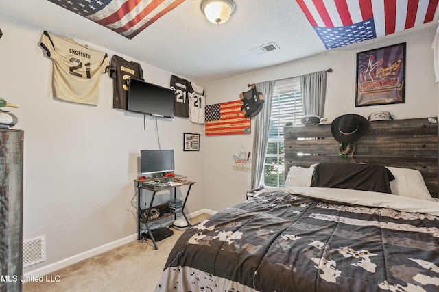 bedroom featuring carpet, visible vents, and a textured ceiling