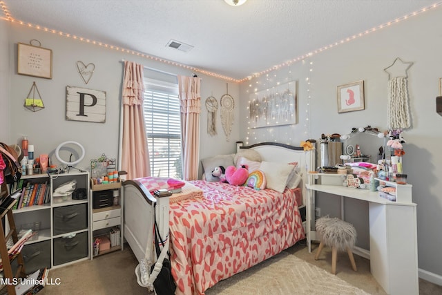 bedroom featuring carpet floors, visible vents, and a textured ceiling