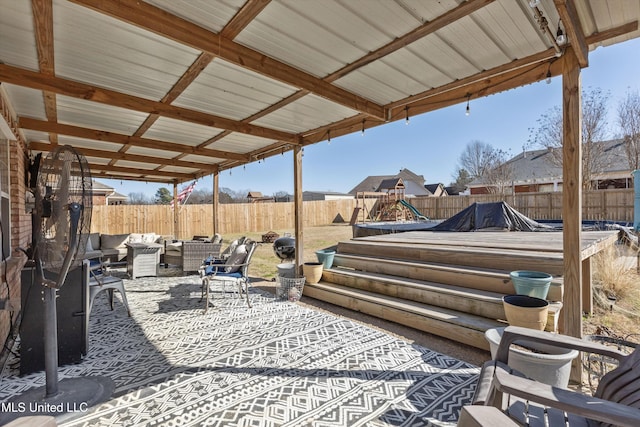 view of patio featuring a playground, a fenced backyard, and an outdoor hangout area